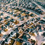 High-angle aerial shot of a suburban neighborhood in Herriman, Utah showcasing residential architecture and streets.
