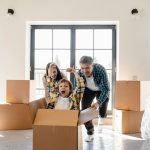Happy family enjoying a new home moving day, with boxes and laughter.