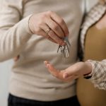 Happy couple receiving keys to their new home, symbolizing a new beginning.